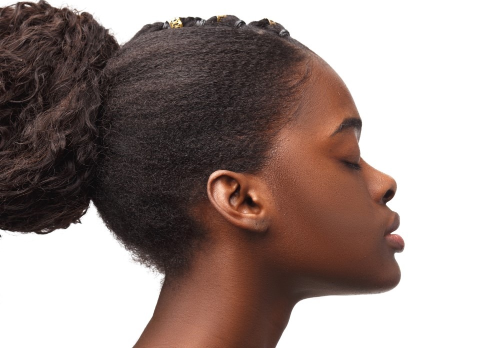 Belle femme africaine détenant des cheveux afros 